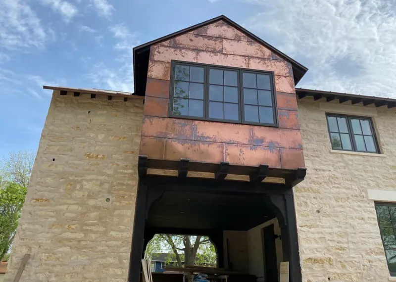 Copper metal panel facade on a stone building for Roof Repair in Blackman